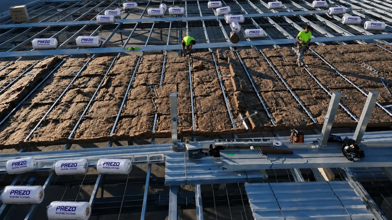 PREZO roofing insulation being installed on a commercial steel roof